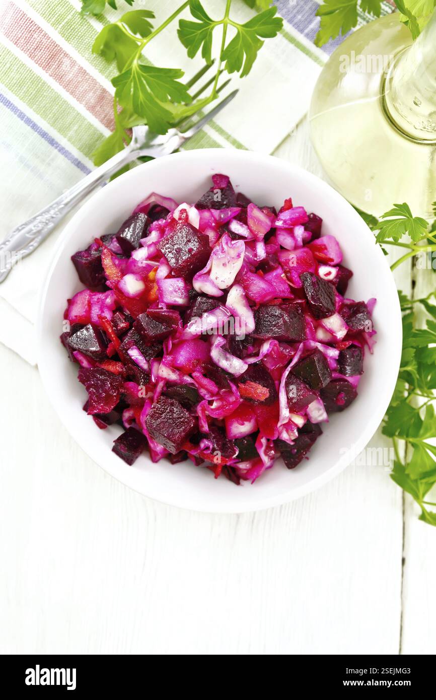 Salade Vinaigrette au vinaigre ou avec de la choucroute, pommes de terre, betterave et l'oignon, assaisonnés avec de l'huile végétale dans un bol, serviette, le persil sur l'arrière-plan o Banque D'Images