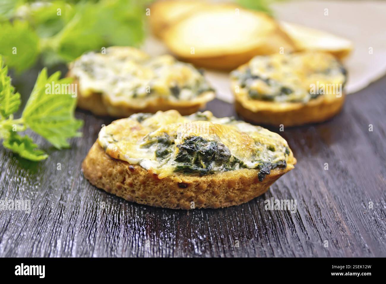 Sandwichs chauds, avec l'ortie et le fromage sur les tranches de pain de blé, l'ail et l'huile végétale sur l'arrière-plan des chambres Banque D'Images