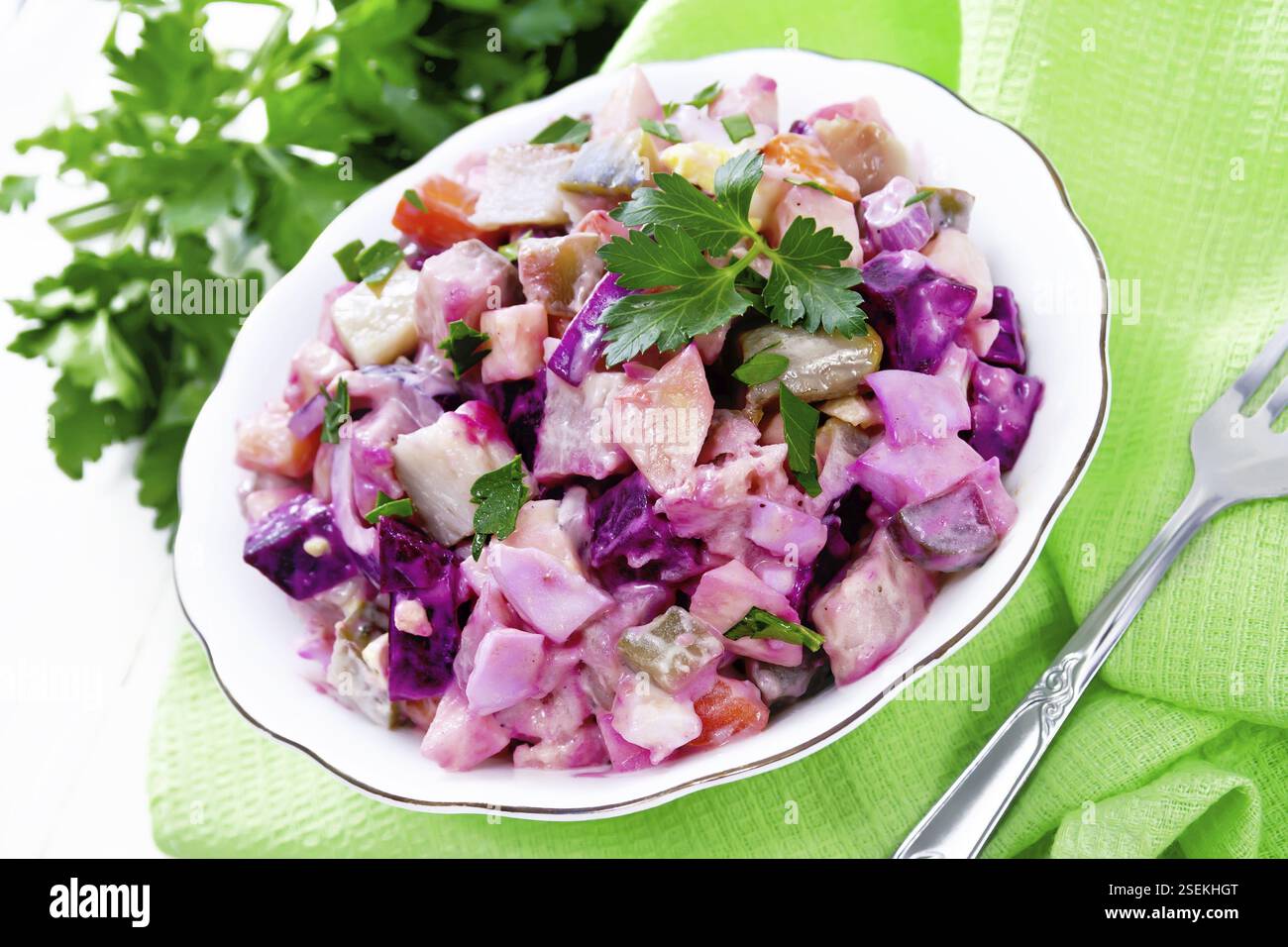 Salade de rosoli finnoise avec hareng, betterave, pommes de terre, concombres marinés ou marinés, carottes, oignons et œufs, vêtus de mayonnaise dans un bol sur wh Banque D'Images