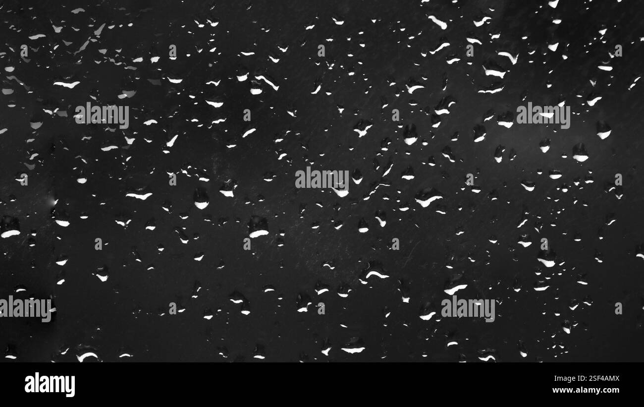 Petites gouttes d'eau sur la fenêtre la nuit, eau sur le verre après la pluie. Banque D'Images