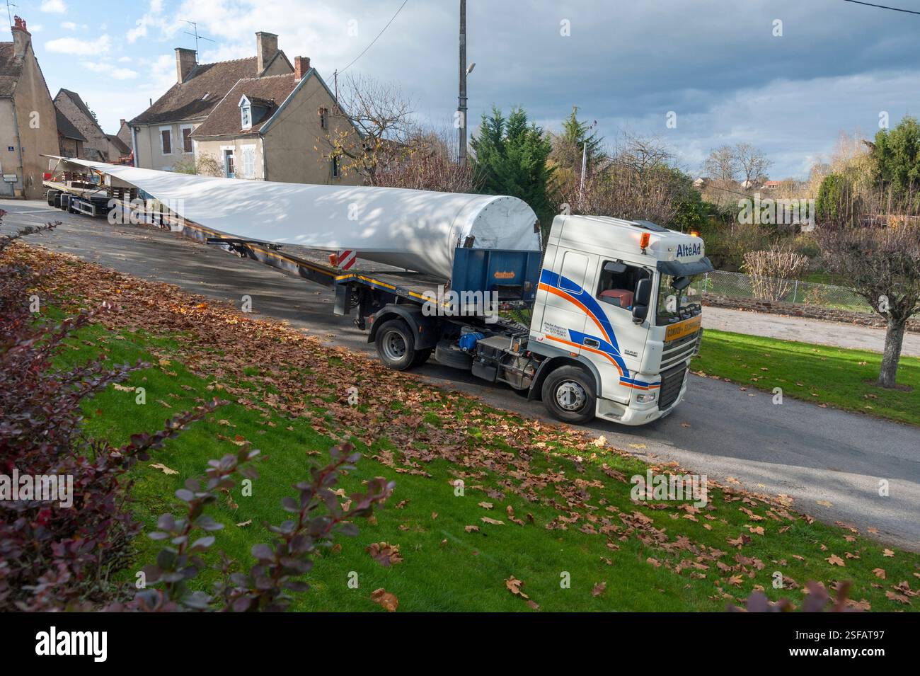 Un convoi exceptionnel transportant une pale d’éolienne manœuvre pour changer de direction. Banque D'Images