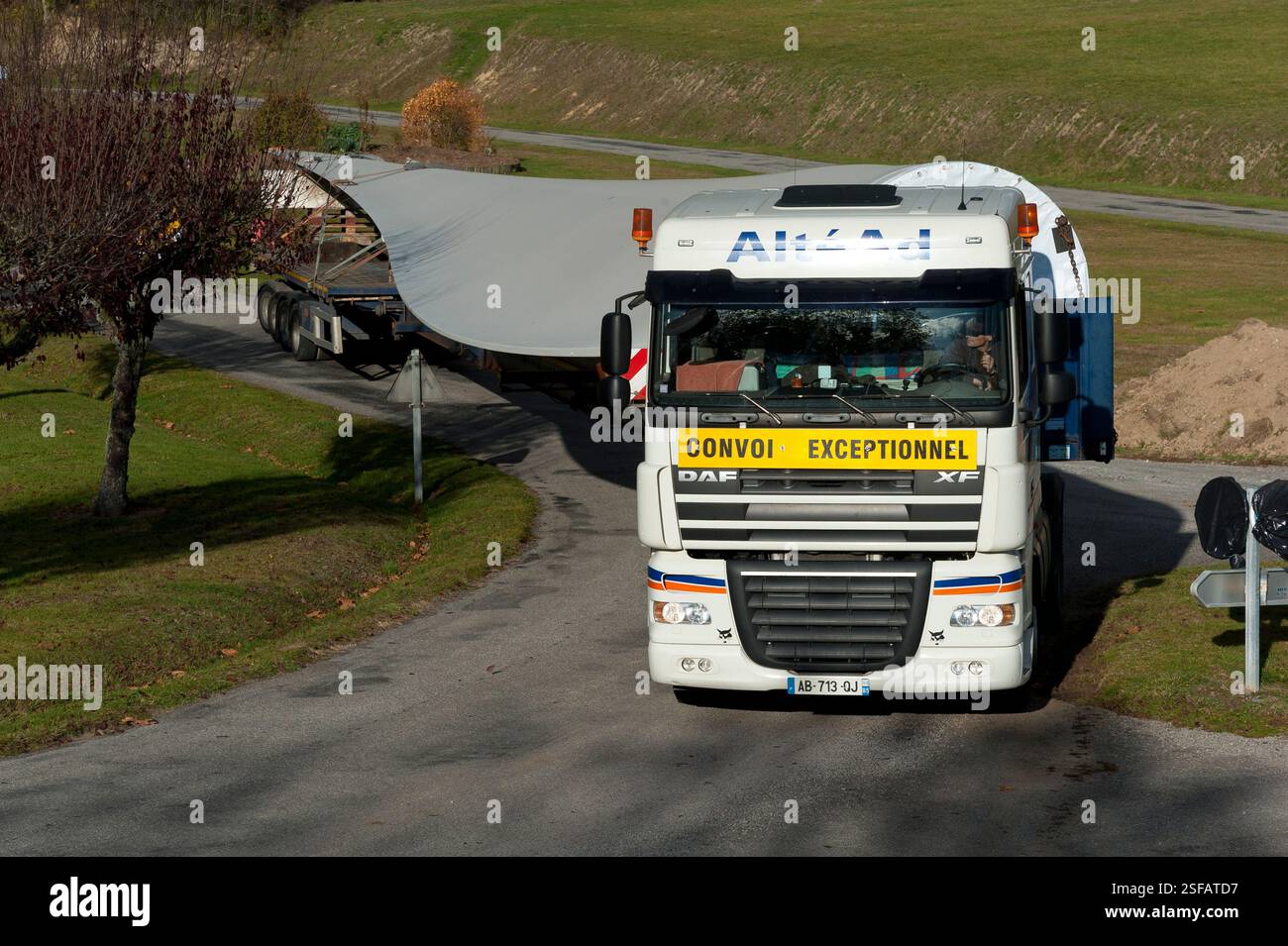 Un convoi exceptionnel transportant une pale d’éolienne manœuvre pour changer de direction. Banque D'Images