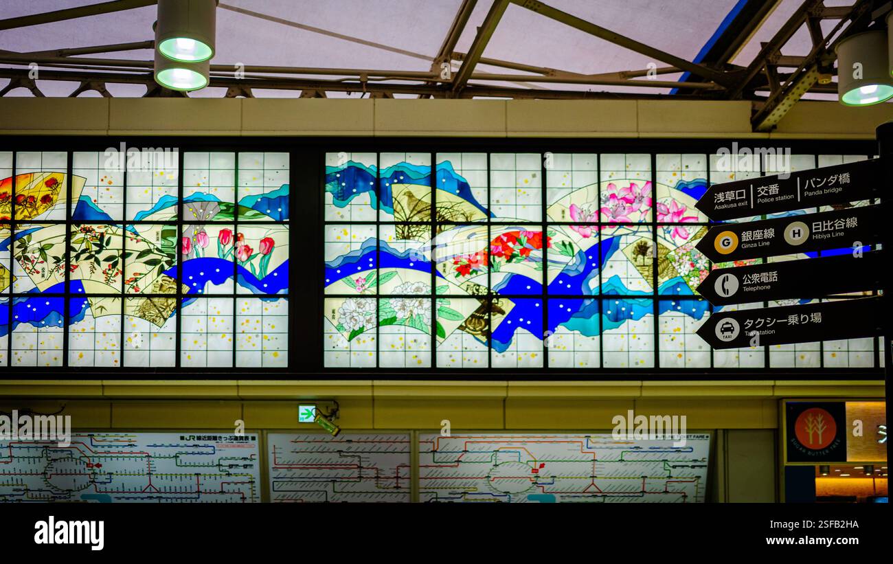 Une murale de vitraux vibrante à l'intérieur de la gare d'Ueno à Tokyo, au Japon, mettant en vedette un design coloré de fleurs, de cieux étoilés et de fans japonais. L'illum Banque D'Images