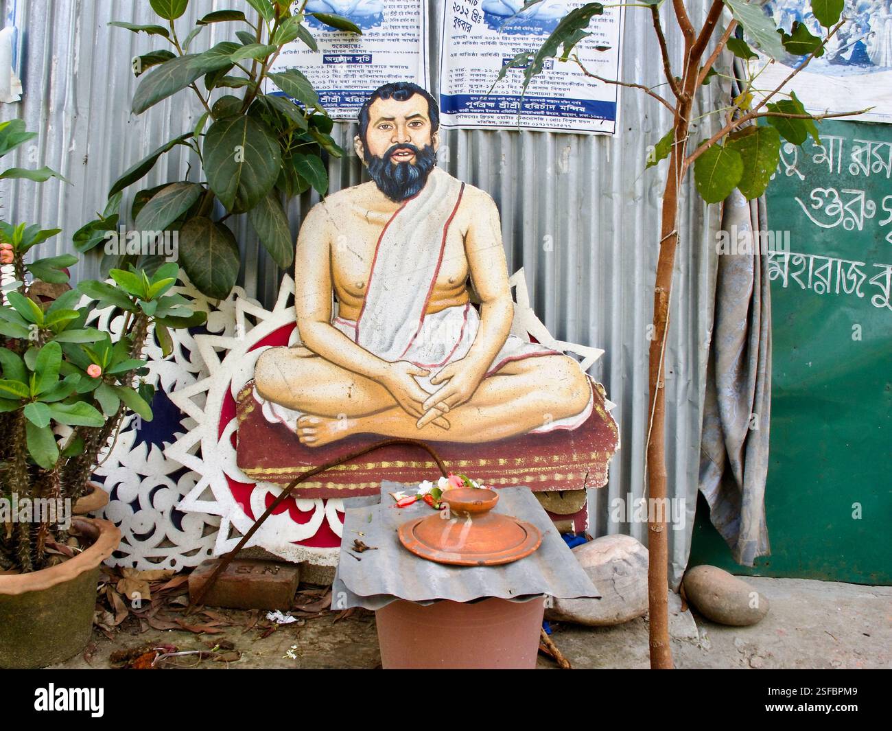 Un petit sanctuaire extérieur au temple Ramna Kali, Dhaka, avec une représentation peinte de Sri Ramakrishna Paramahamsa avec des offrandes rituelles. Banque D'Images