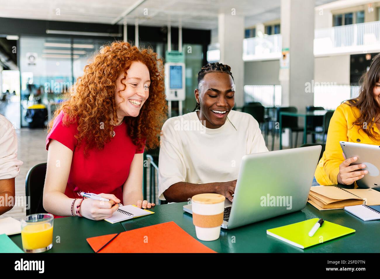 Groupe diversifié d'étudiants universitaires étudiant ensemble à la cafétéria de l'université. Banque D'Images