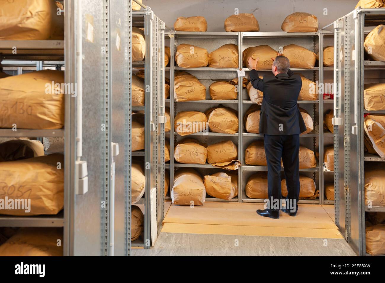 Ein Mitarbeiter entnimmt am 23.05.2011 einen Sack mit vernichteten Stasi-Akten in einem Lager der Bundesstelle des Bundesbeauftragten BStU der ehemaligen ostdeutschen Geheimpolizei Stasi in Magdeburg in Saxe-Anhalt. Die Bundesverwaltung lagert à Magdebourg 9,000 Papiersaecke. Die Bundesstelle des Bundesbeauftragten BStU bewahrt in ihrem Archiv die Unterlagen des Ministeriums fuer Staatssicherheit der DDR auf und stellt diese unter Einhaltung strenger gesetzlicher Vorschriften Privatpersonen, Institutionen und der Oeffentlichkeit fuer verschiedene Zwecke zur Verfuegung. Un employé sort Banque D'Images