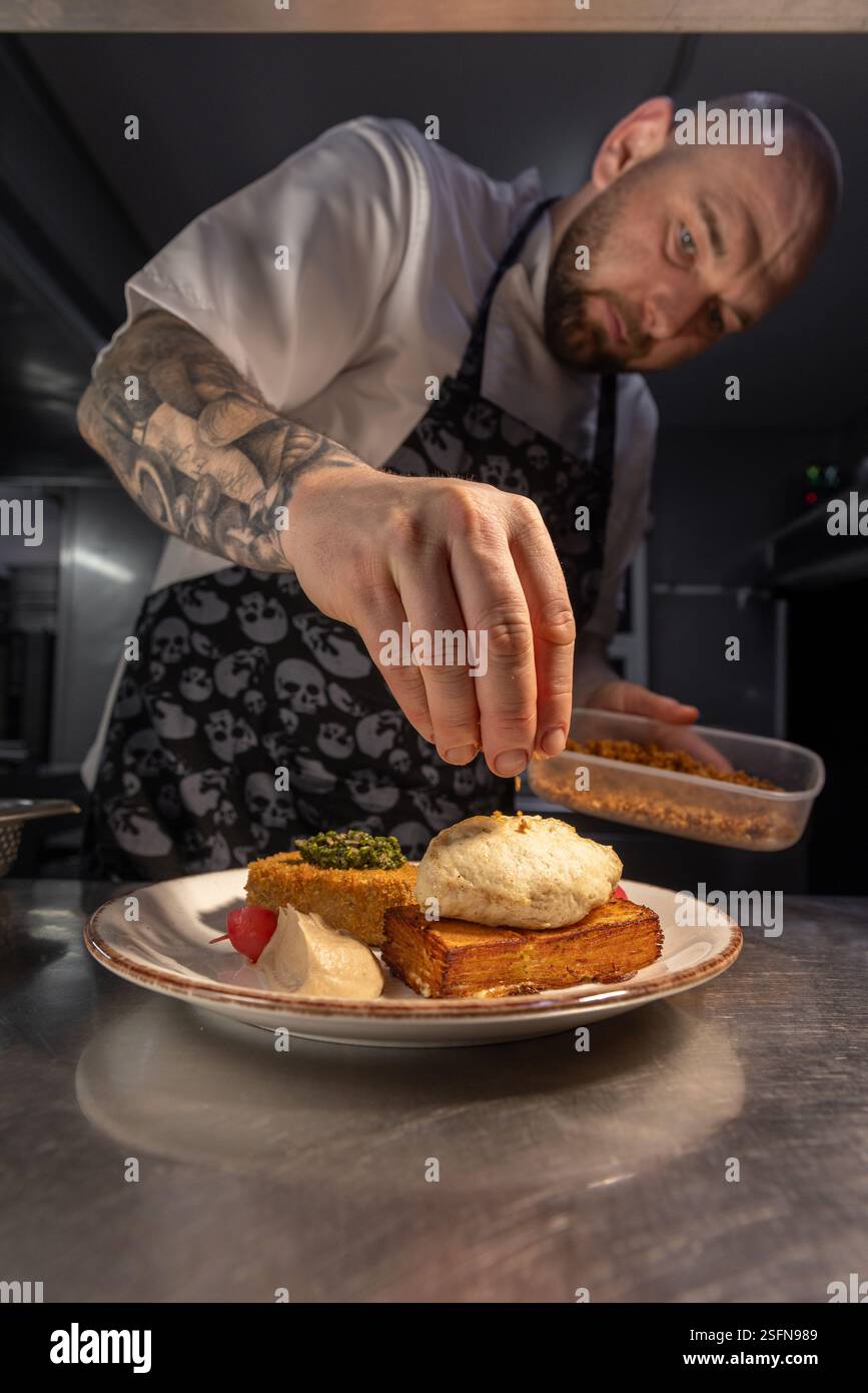 Chef garnissant un plat gastronomique avec des croûtons dans la cuisine du restaurant Banque D'Images