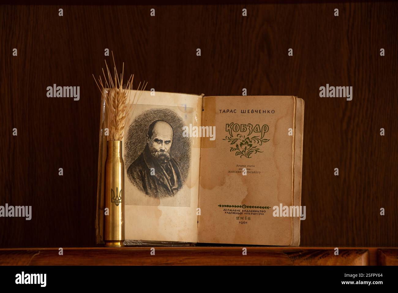 Ukraine Dnepr février 09, 2025 - Livre Kobzar Taras Shevchenko et un étui de cartouche avec les armoiries de l'Ukraine et une épi de blé sur une étagère Banque D'Images