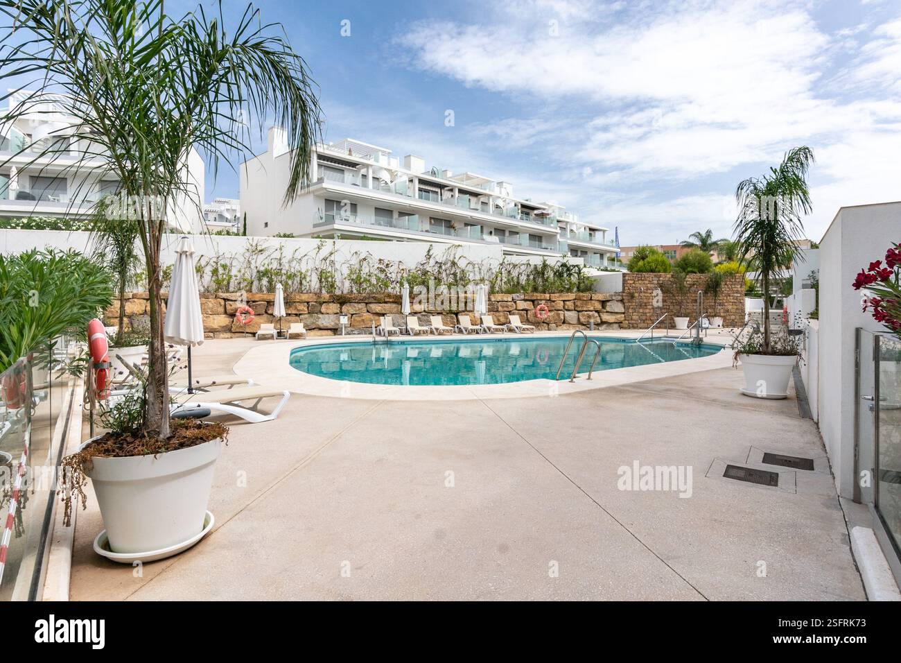 une image d'une piscine communautaire de luxe avec des chaises longues dans le complexe méditerranéen de maisons de vacances Banque D'Images