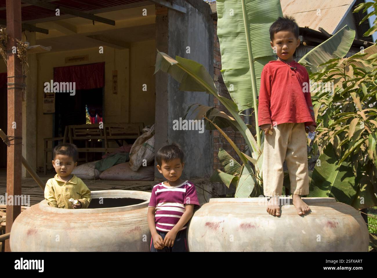 Les enfants jouent dans des jarres d'eau dans un village sur le lac Tonle SAP, près de Siem Reap Banque D'Images