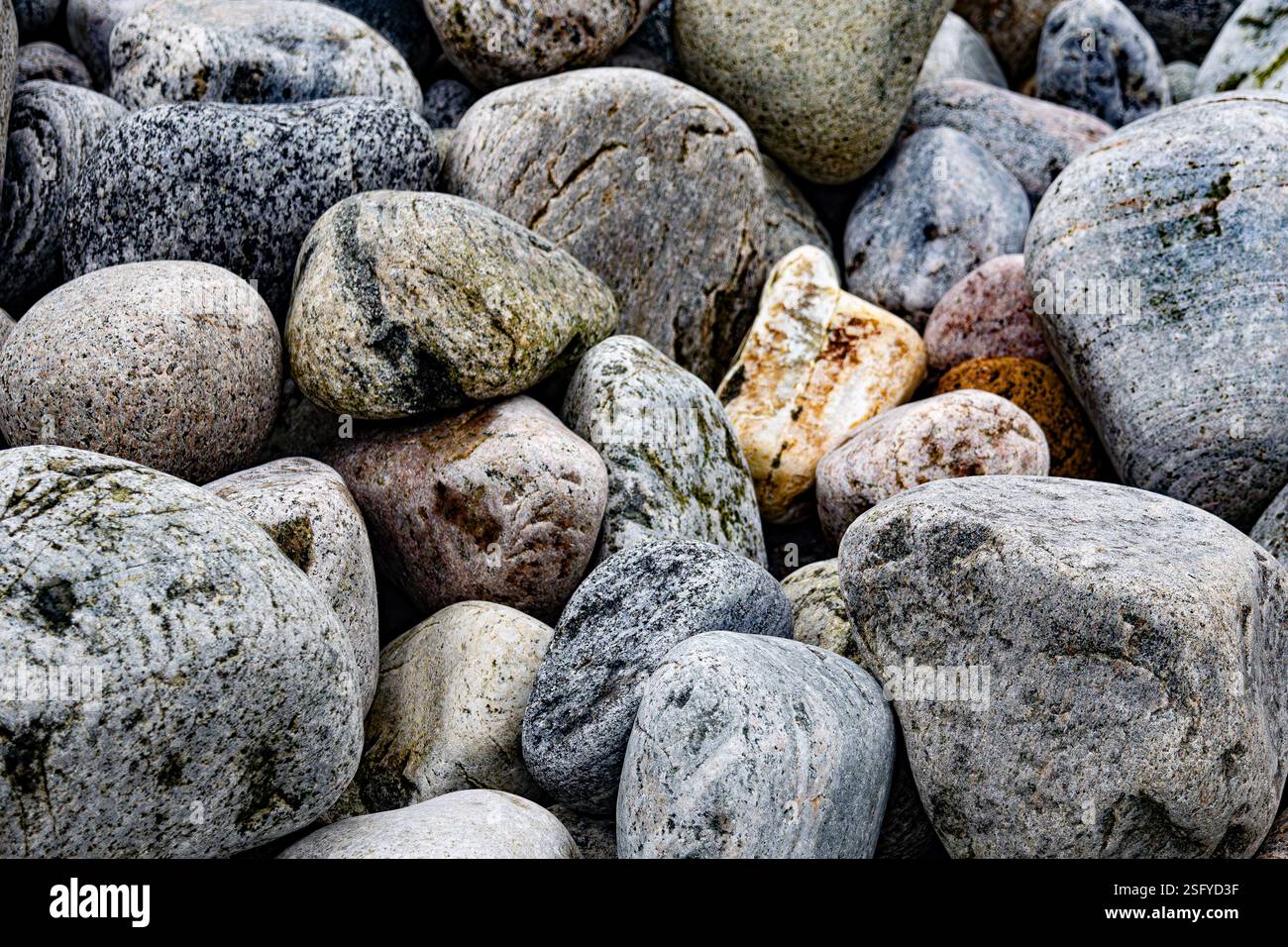 Une vue sereine sur un rullesteinstrand (plage de galets) le long de la côte norvégienne accidentée. Pierres lisses de différentes tailles et couleurs. Banque D'Images