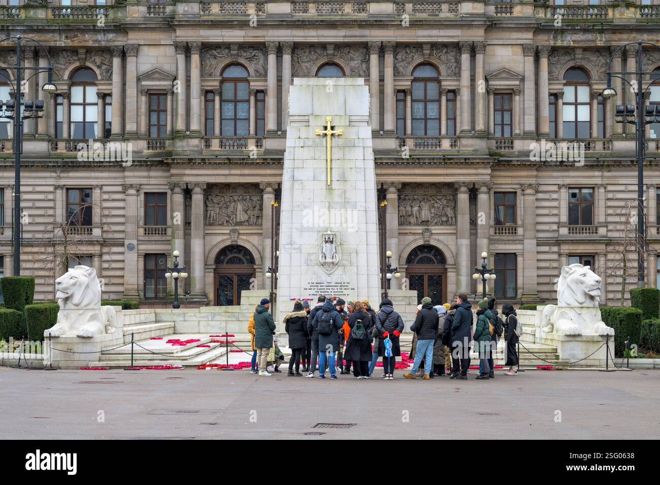 Un groupe de visite et un guide sur George Square à côté du cénotaphe et de City Chambers, Glasgow, Écosse, Royaume-Uni, Europe Banque D'Images