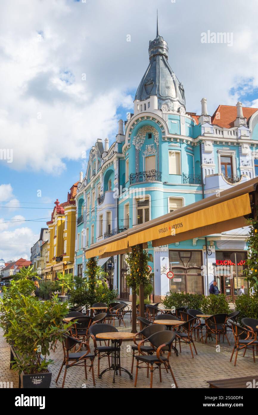 Oradea, Roumanie - 07 octobre 2024 : Rue, terrasse et bâtiment Art Nouveau dans la ville d'Oradea, Roumanie Banque D'Images