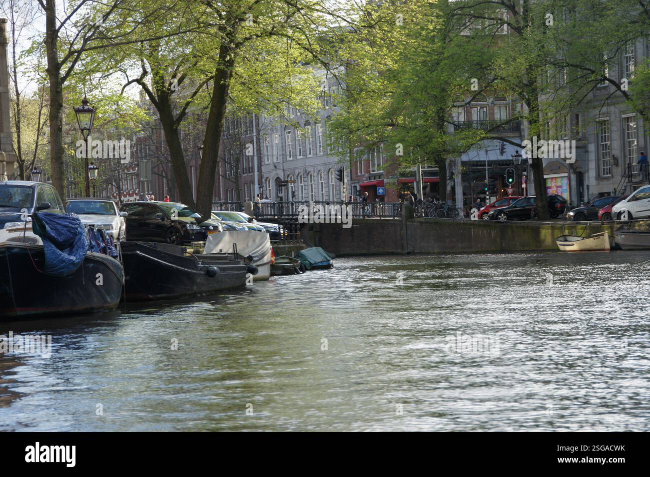 Amsterdam. Un canal paisible bordé de bateaux et de voitures stationnés. L'eau calme serpente à travers la ville, une scène pittoresque et un itinéraire possible pour un CA Banque D'Images