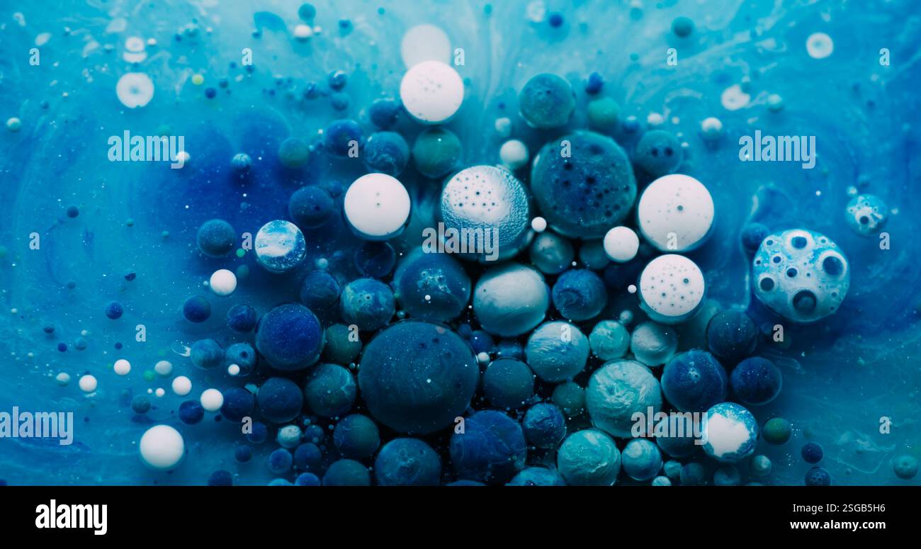 Bulle d'huile. Mélange de peinture. Gouttes de gel coloré flottant sur la surface de l'eau de marbre. Fond liquide de particules abstraites blanches bleues fantastiques. Banque D'Images