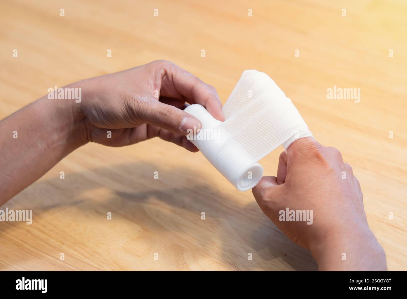 Photo en gros plan du doigt de l'homme avec bandage. Premiers soins en cas de petite blessure domestique. Concept de bandage de gaze. Banque D'Images
