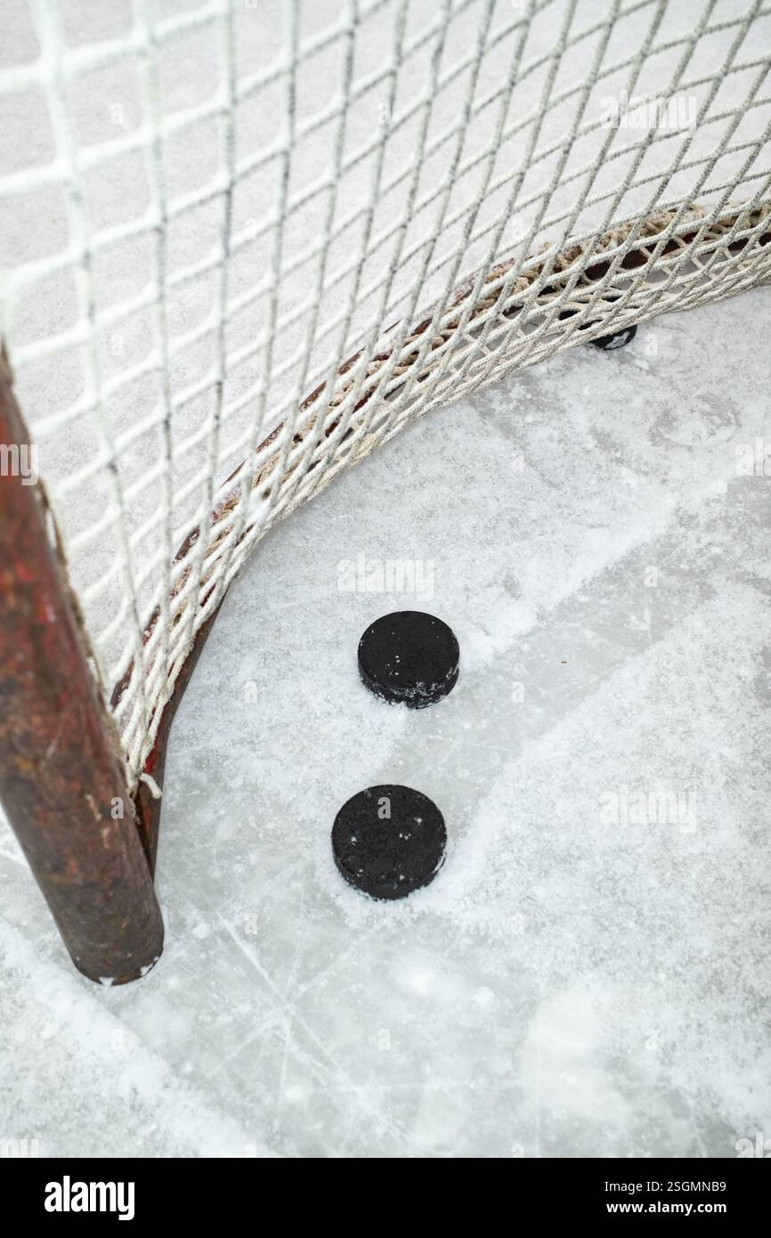 Hockey Pucks près du but sur une patinoire enneigée Banque D'Images