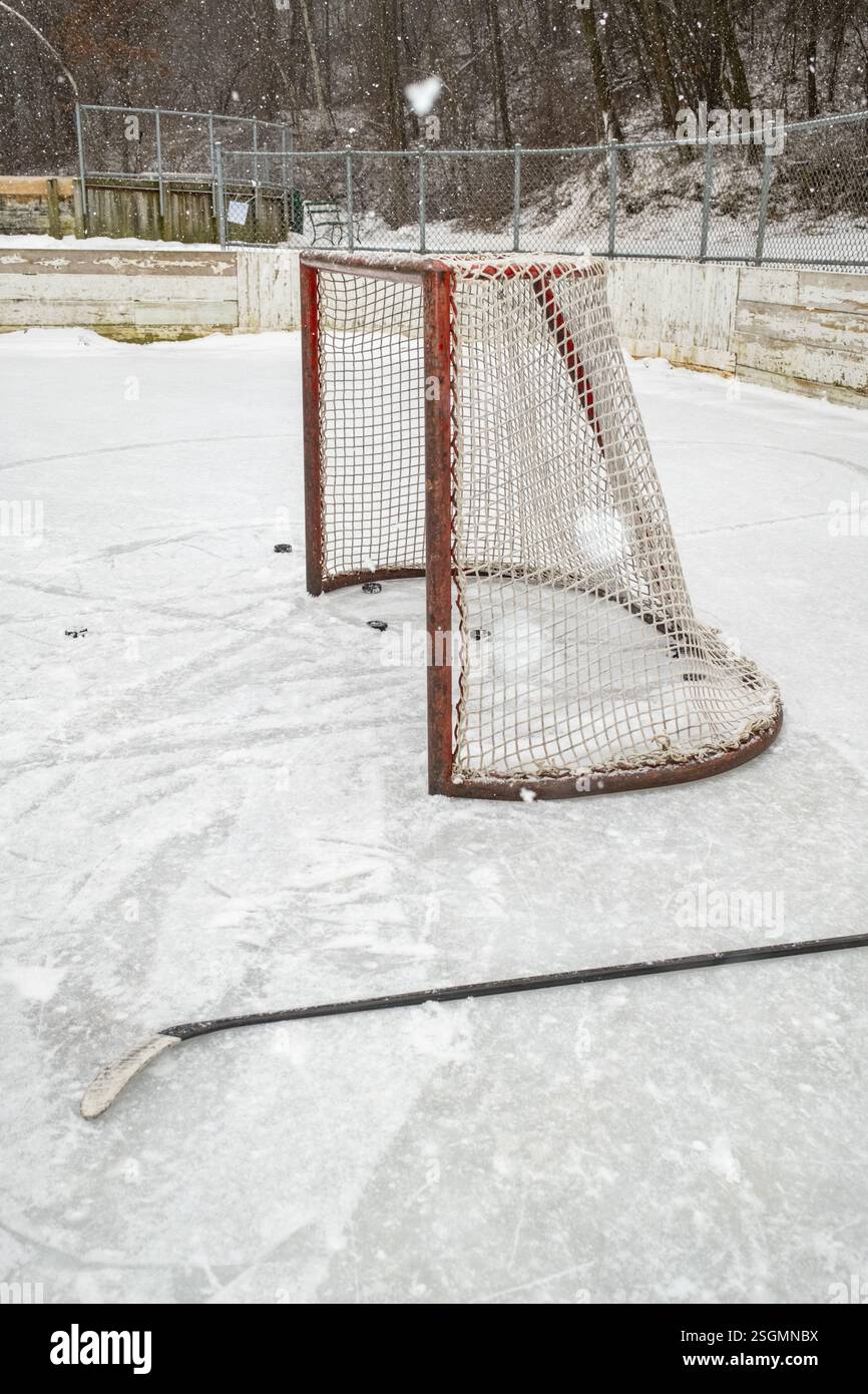 Objectif et bâton de hockey sur la patinoire extérieure enneigée Banque D'Images