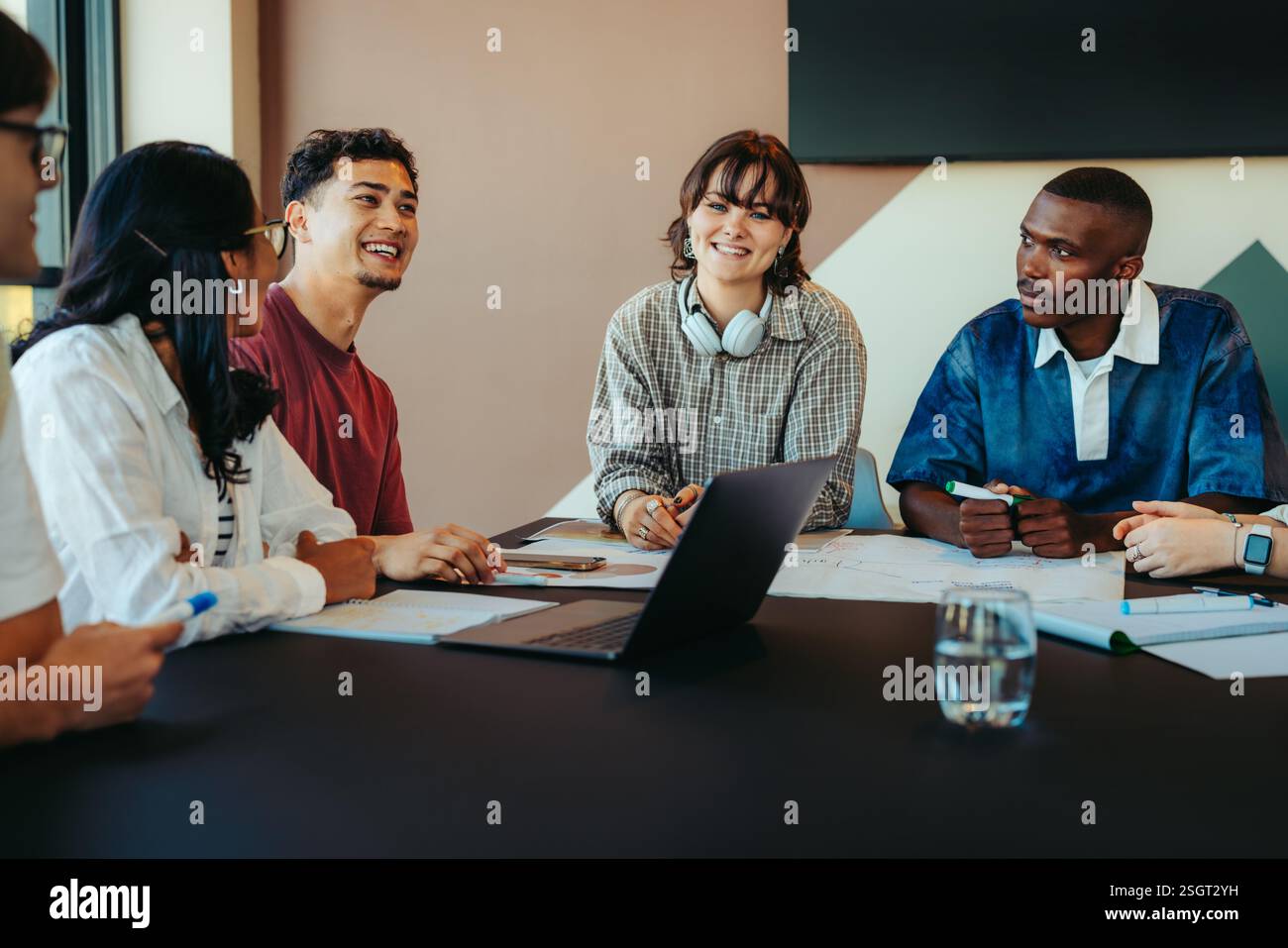 Un groupe diversifié de camarades de classe travaillant ensemble et partageant des idées dans une salle de classe, favorisant le travail d'équipe et la collaboration dans un environnement moderne et engageant Banque D'Images