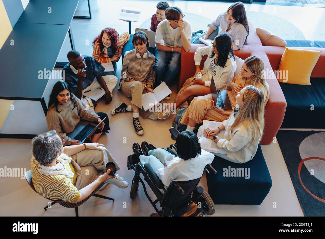 Réunion de groupe diversifiée dans une bibliothèque, mettant en valeur le travail d'équipe et la collaboration dans un cadre moderne et inclusif. Banque D'Images