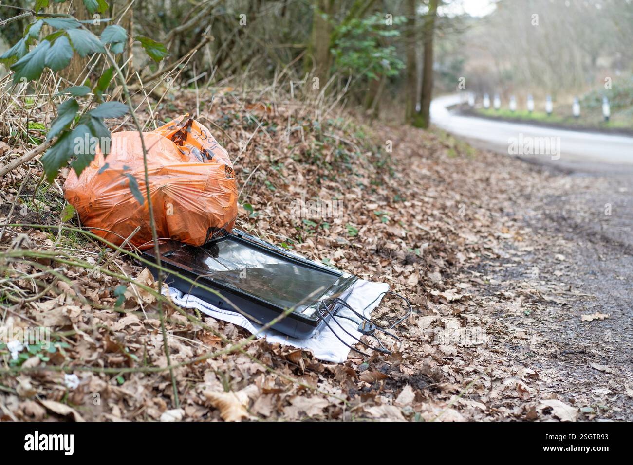 Astuce aérienne britannique : sac de déchets résidentiels et téléviseur à écran plat cassé jeté sur une serviette laissée sur le bord de la route le long d'une voie de campagne (voie publique). Banque D'Images