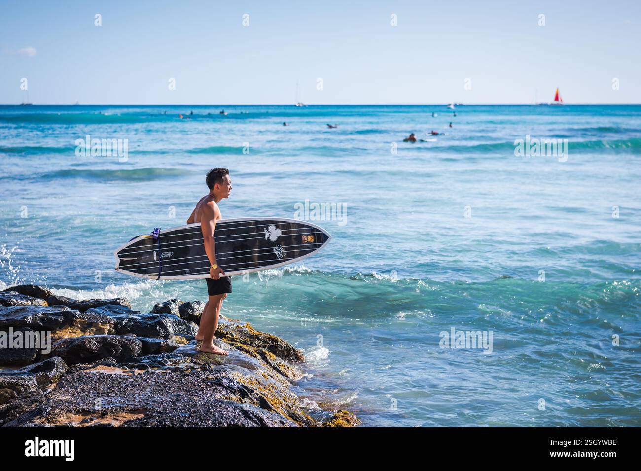 Honolulu, Hawaï - États-Unis - 1er septembre 2018 : un jeune surfeur se prépare à surfer au Kuhiio Beach Park. Banque D'Images