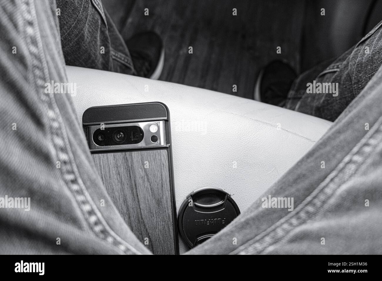 Gros plan minimaliste noir et blanc d'un smartphone dans un habitacle de voiture Banque D'Images