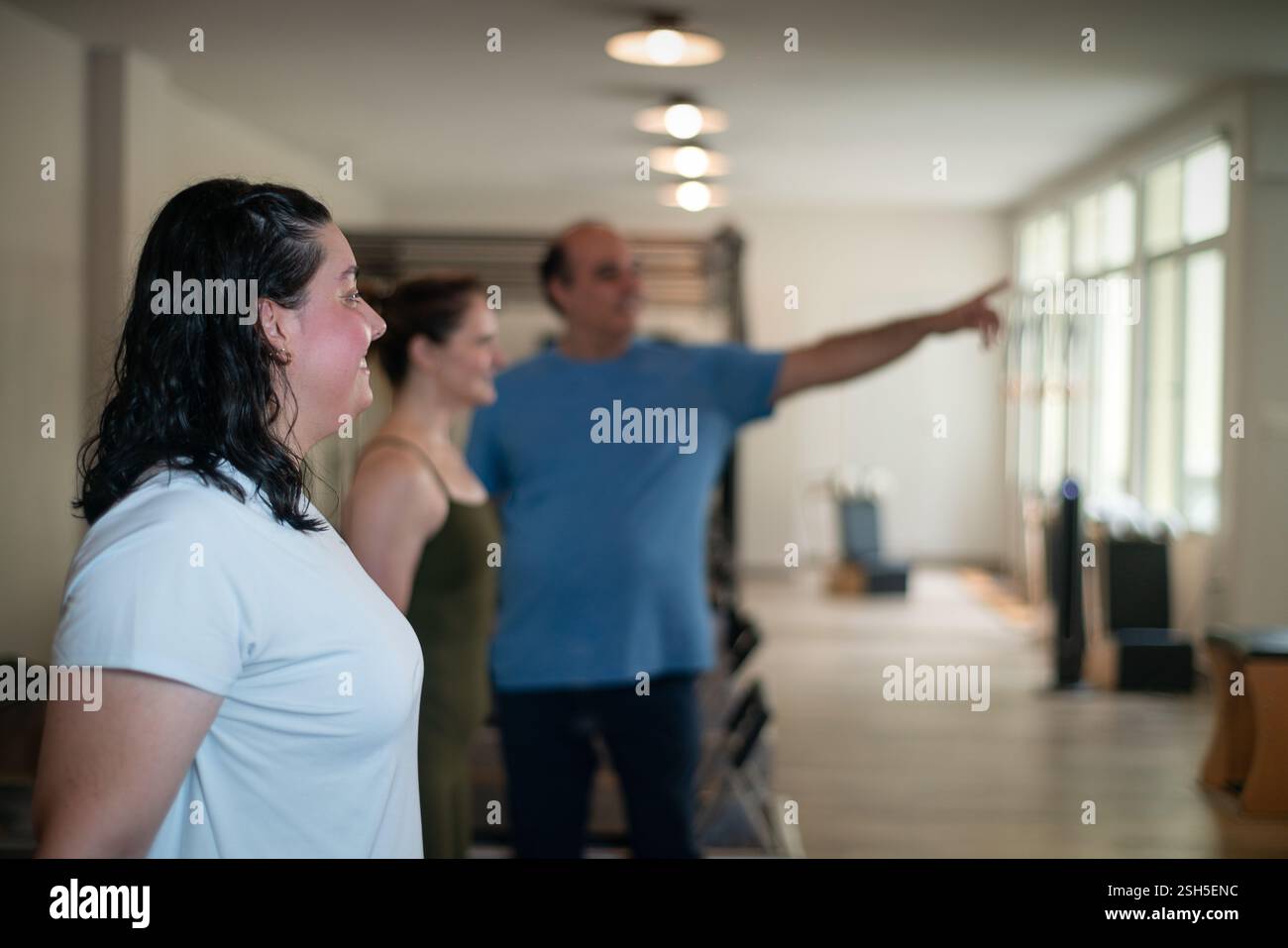 Séance de Pilates avec un entraîneur indiquant la bonne direction de posture. Banque D'Images