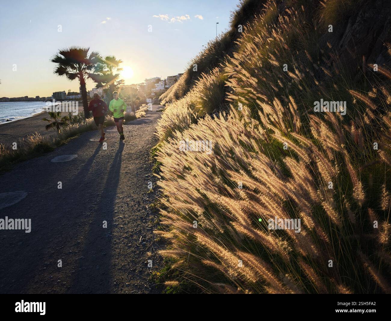 Deux personnes pratiquant le sport sur une route de campagne à Benalmadena, Espagne. Banque D'Images