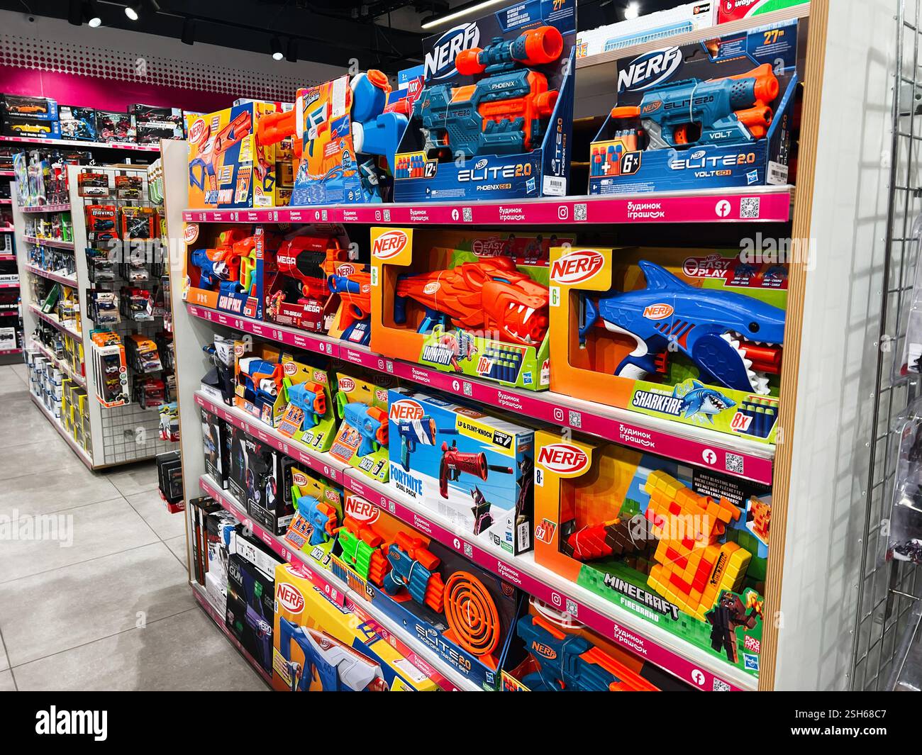 Kiev, Ukraine - 09 février 2025 : allée de magasin de jouets très éclairée présentant des jouets nerf et des emballages colorés sur les étagères Banque D'Images