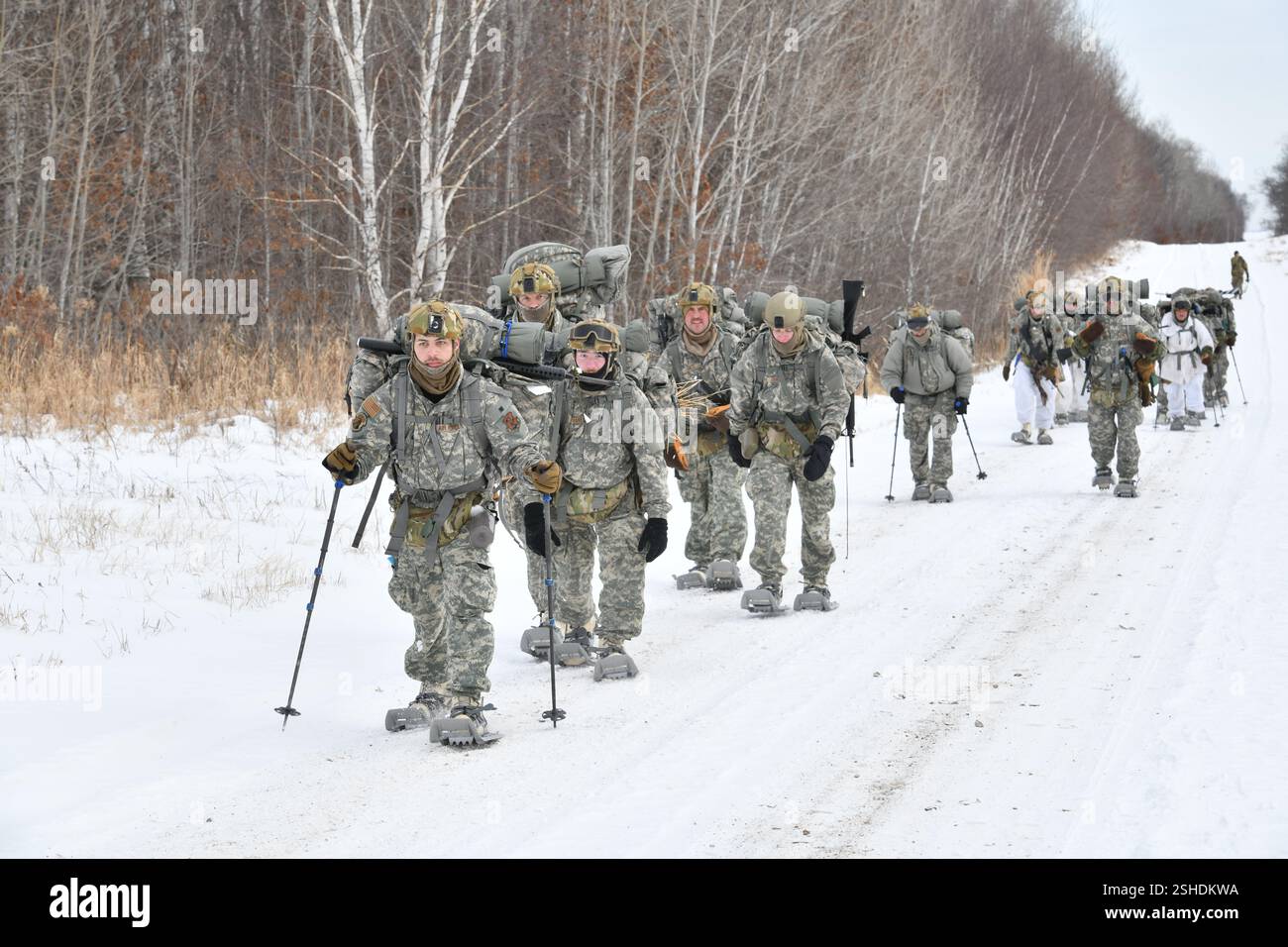 Les aviateurs de la Garde nationale de l'Air effectuent un ruck de six milles, transportant des sacs, dans le cadre du cours d'opérations par temps froid de la Garde nationale de l'Air au Camp Ripley Training Center, Minnesota, le 4 février 2025. 70 participants de classe représentant 37 ailes de 27 états ont voyagé à pied dans des températures inférieures à zéro, pour construire des abris thermiques fabriqués à partir de matériaux trouvés dans la nature. Les étudiants étaient principalement des spécialistes des Forces de sécurité, mais comprenaient également un commandant du Groupe de maintenance, un assistant médical, un spécialiste des cybercommunications et un spécialiste des affaires publiques. Le cours de deux semaines comportait un trai de six jours et cinq nuits Banque D'Images