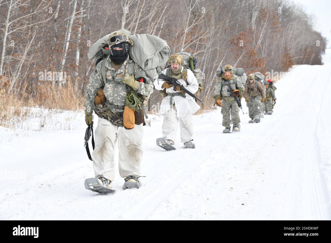 Les aviateurs de la Garde nationale de l'Air effectuent un ruck de six milles, transportant des sacs, dans le cadre du cours d'opérations par temps froid de la Garde nationale de l'Air au Camp Ripley Training Center, Minnesota, le 4 février 2025. 70 participants de classe représentant 37 ailes de 27 états ont voyagé à pied dans des températures inférieures à zéro, pour construire des abris thermiques fabriqués à partir de matériaux trouvés dans la nature. Les étudiants étaient principalement des spécialistes des Forces de sécurité, mais comprenaient également un commandant du Groupe de maintenance, un assistant médical, un spécialiste des cybercommunications et un spécialiste des affaires publiques. Le cours de deux semaines comportait un trai de six jours et cinq nuits Banque D'Images