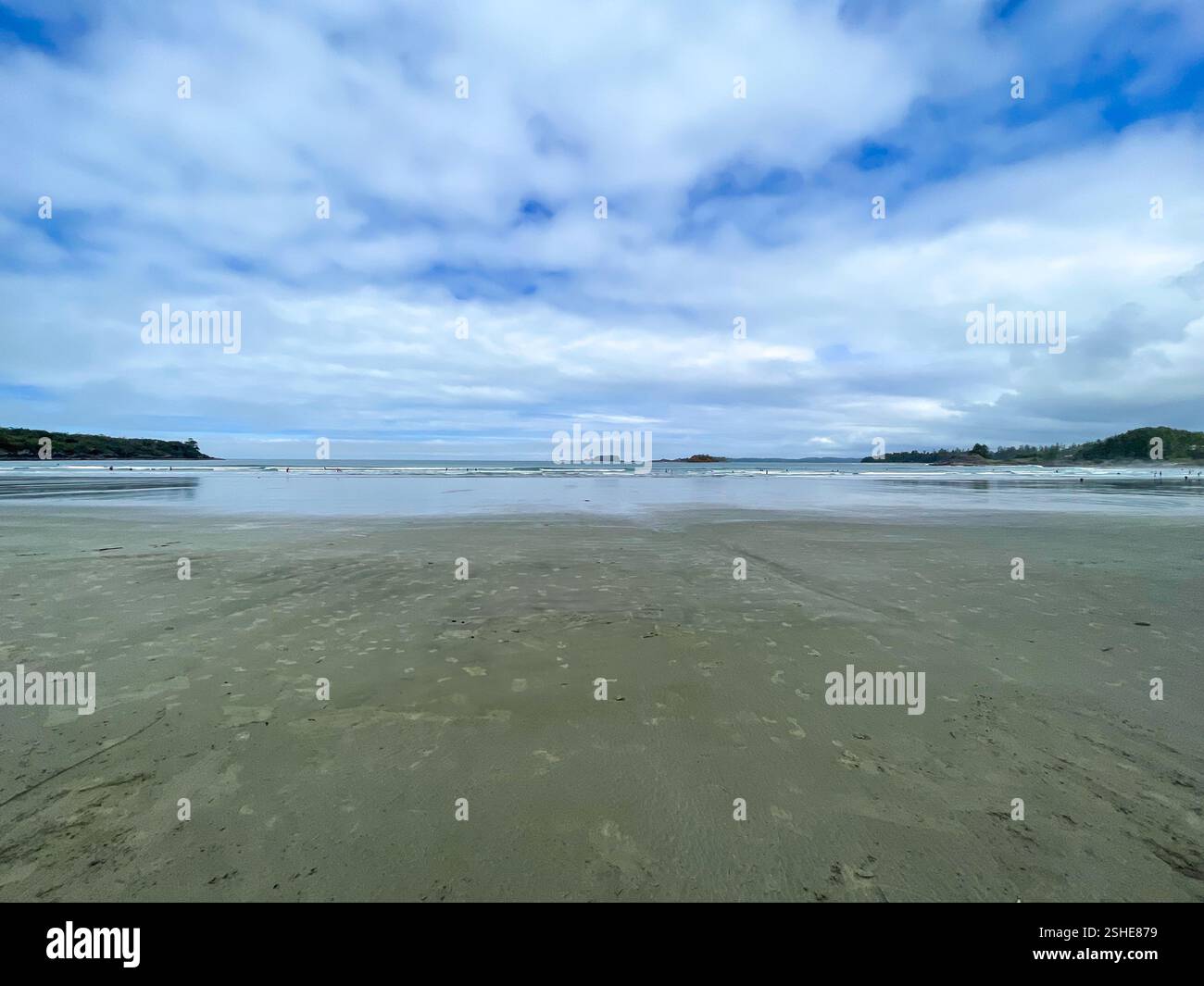 Vue minimaliste sur la plage de sable sous un ciel bleu nuageux, avec des eaux calmes. Idéal pour les voyages, la détente et la photographie de la nature. - Image de stock capturée avec un smartphone