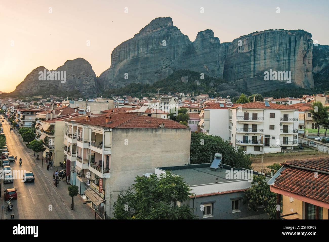 Kalambaka : Trikalon Street, avec les montagnes des Météores en arrière-plan, pendant le coucher du soleil. Grèce. Banque D'Images