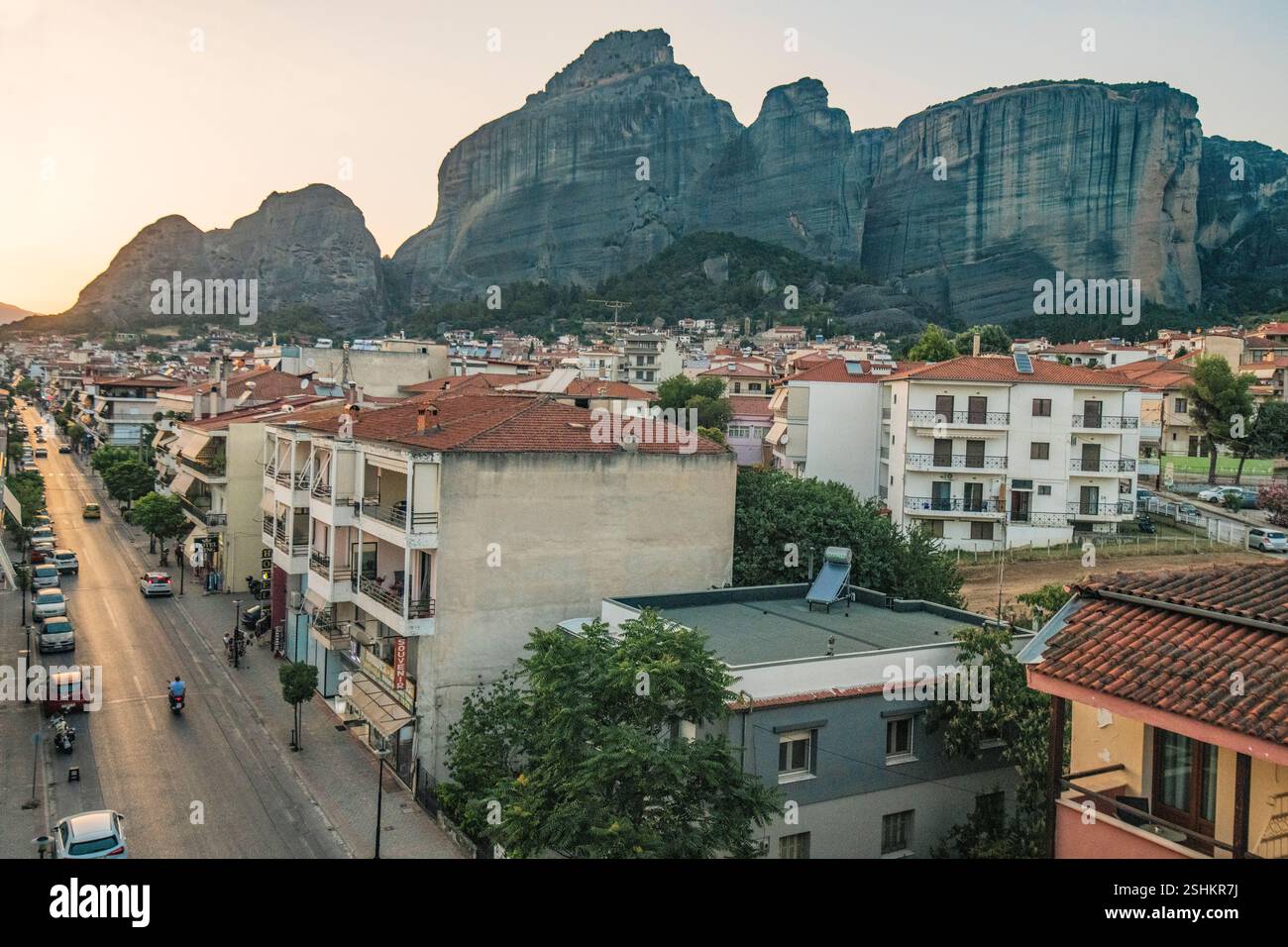 Kalambaka : Trikalon Street, avec les montagnes des Météores en arrière-plan, pendant le coucher du soleil. Grèce. Banque D'Images