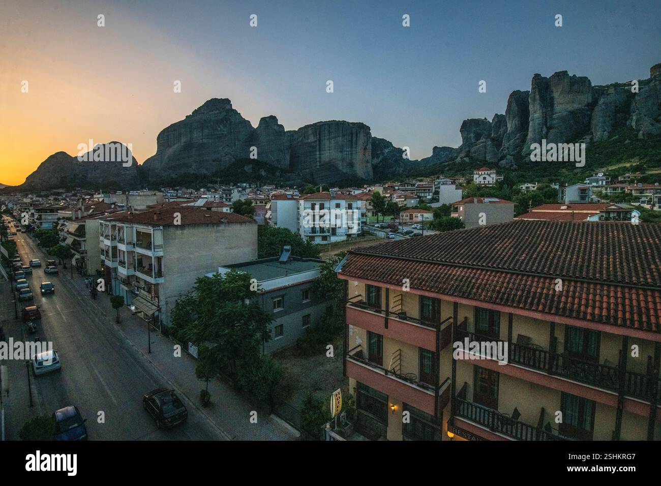 Kalambaka : Trikalon Street, avec les montagnes des Météores en arrière-plan, pendant le coucher du soleil. Grèce. Banque D'Images