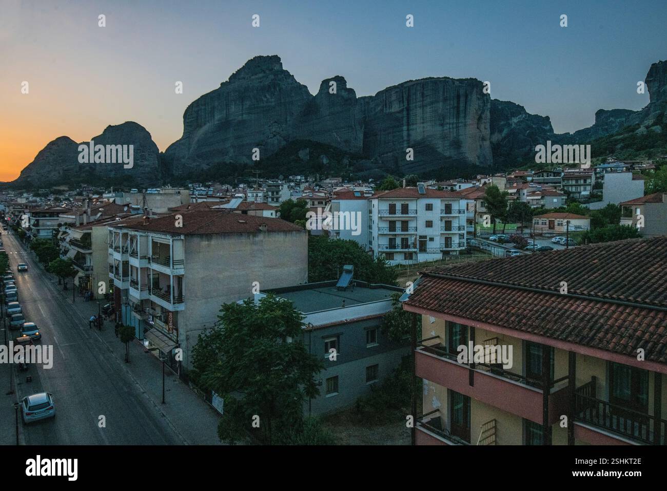 Kalambaka : Trikalon Street, avec les montagnes des Météores en arrière-plan, pendant le coucher du soleil. Grèce. Banque D'Images