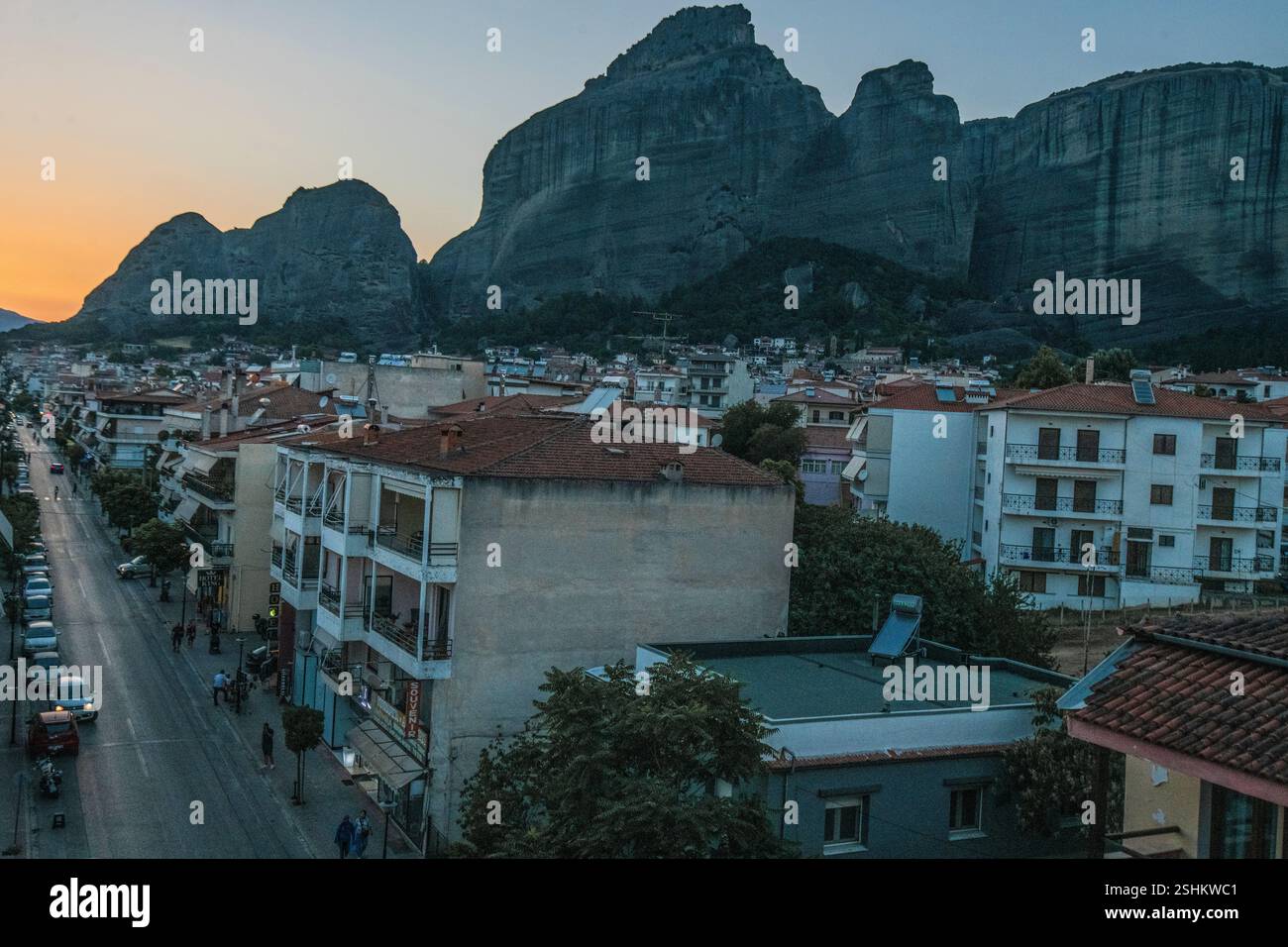 Kalambaka : Trikalon Street, avec les montagnes des Météores en arrière-plan, pendant le coucher du soleil. Grèce. Banque D'Images