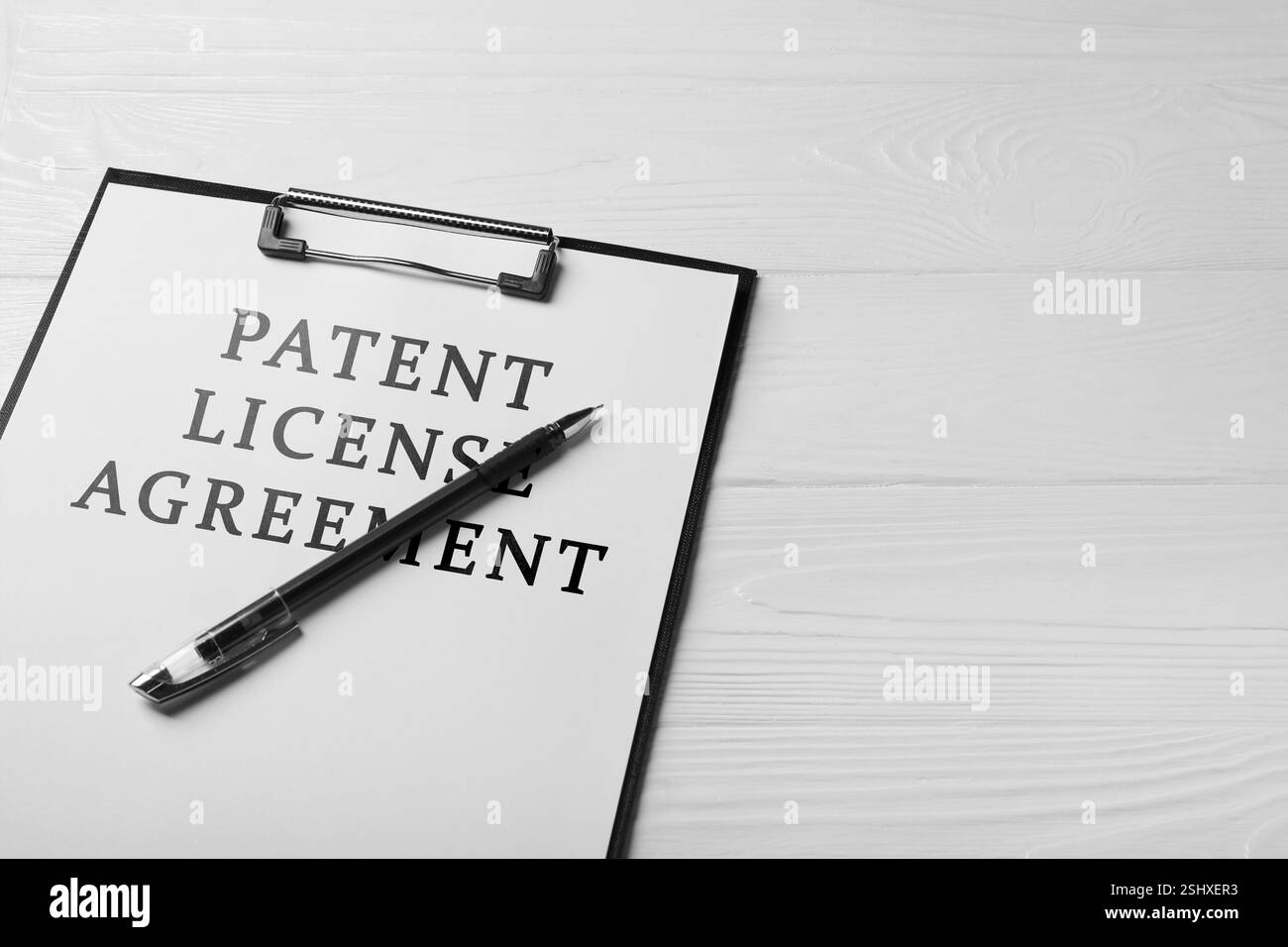Papier avec texte d'accord de licence de brevet et stylo sur table en bois blanc, gros plan Banque D'Images