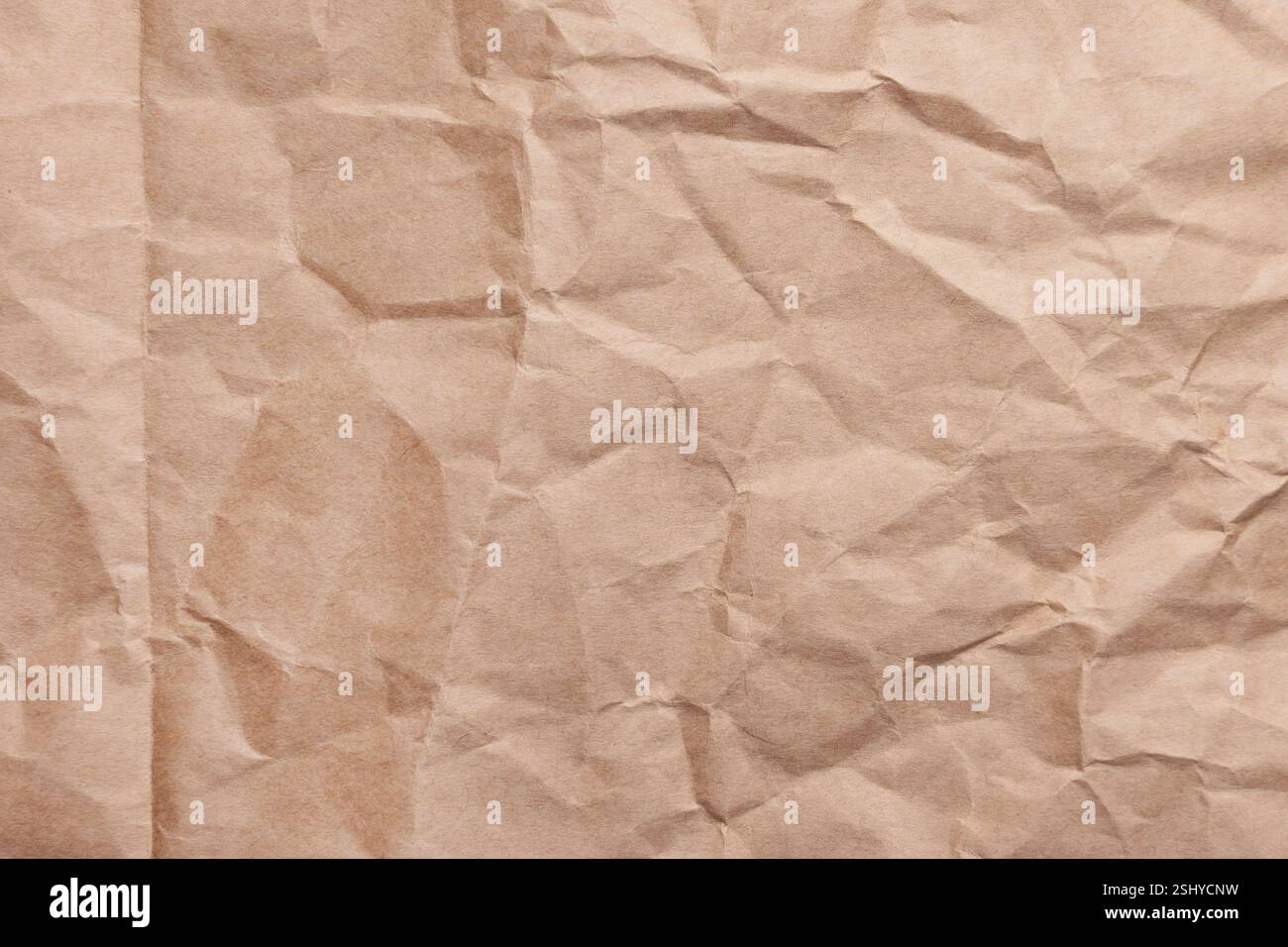 Surface de papier kraft recyclé froissée avec plis et plis. Fond marron froissé texturé respectueux de l'environnement pour l'emballage. Gros plan Banque D'Images