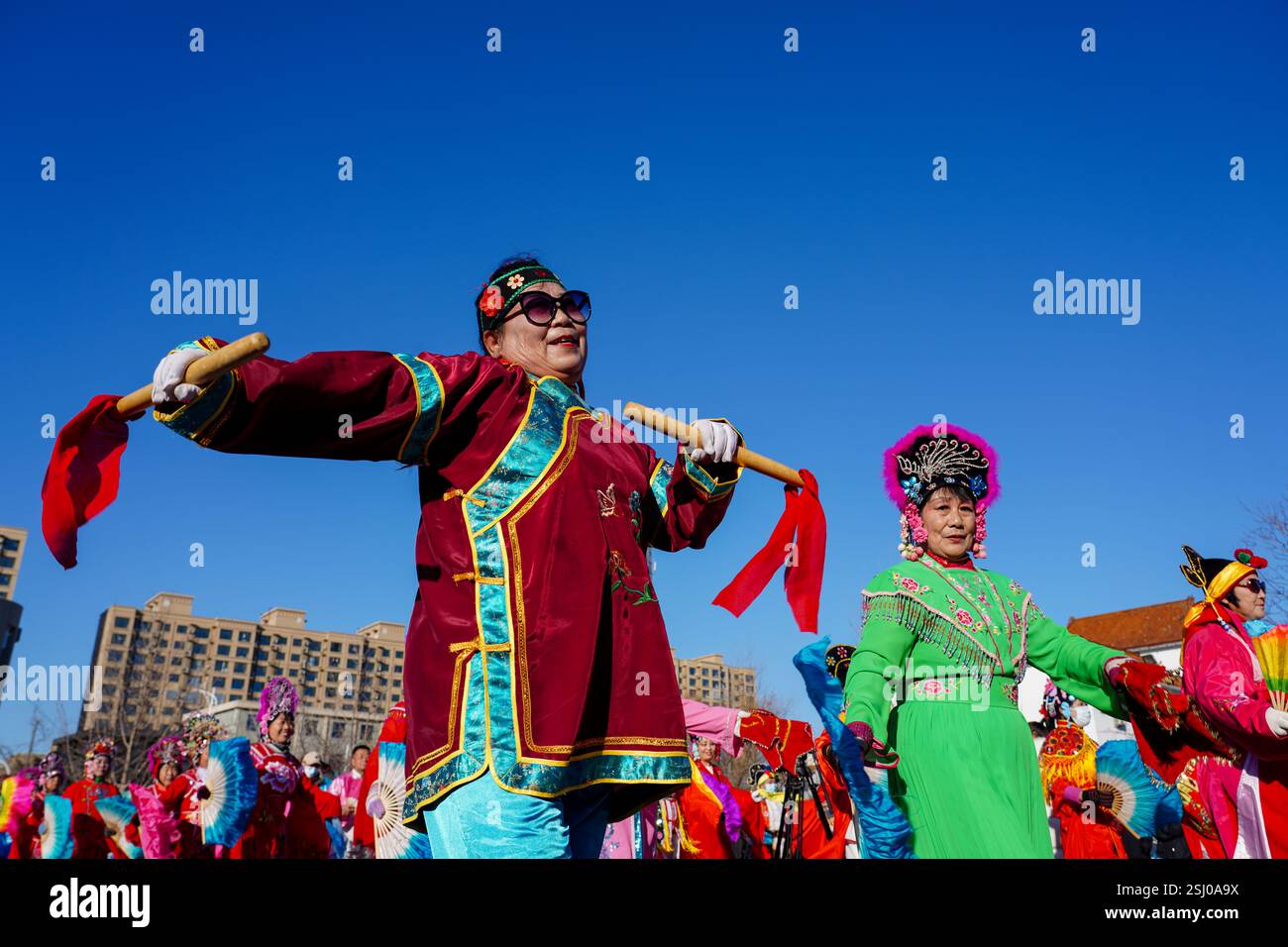 Comté de Luannan, Chine - 12 février 2025 : les gens vêtus de beaux costumes dansent le yangko pour célébrer le nouvel an chinois traditionnel. Banque D'Images