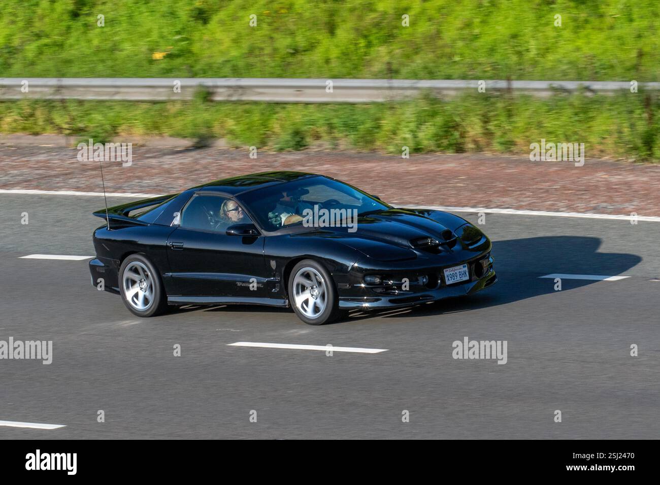2001 Black Pontiac TransAm Firebird muscle supercar voyageant sur l'autoroute M6, Royaume-Uni Banque D'Images