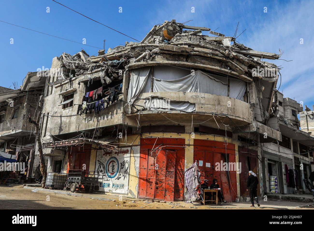 Khan Younis, Territoires palestiniens. 11 février 2025. Des Palestiniens sont assis devant un bâtiment détruit à Khan Younis. Le porte-parole du Hamas Abu Obeida a annoncé le report indéfini de la prochaine série de libérations d'otages israéliennes en raison du non-respect par Israël des termes de l'accord de cessez-le-feu, tandis que le président américain Donald Trump a menacé de détruire tous les bâtiments à Gaza si les otages n'étaient pas libérés comme prévu. Crédit : Abed Rahim Khatib/dpa/Alamy Live News Banque D'Images