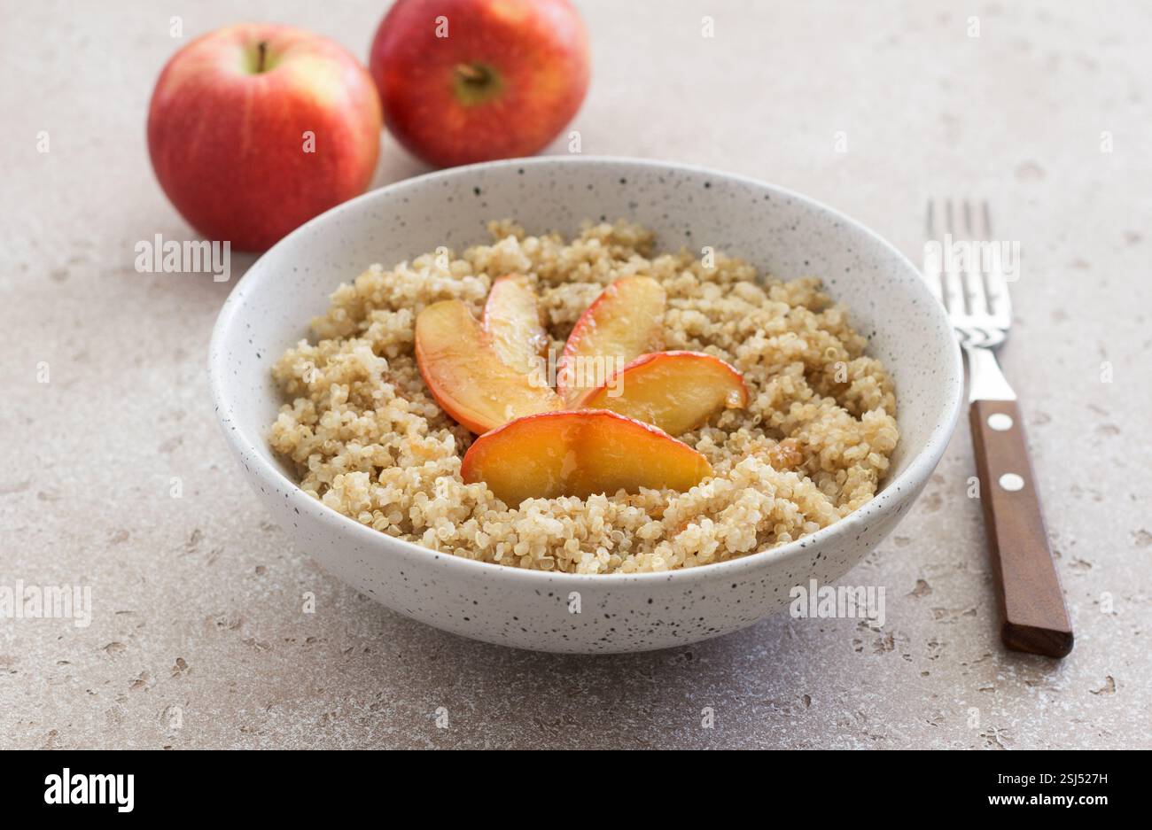 Quinoa avec tranche de pomme caramélisée sur un fond texturé beige. Plat sain végétalien Banque D'Images