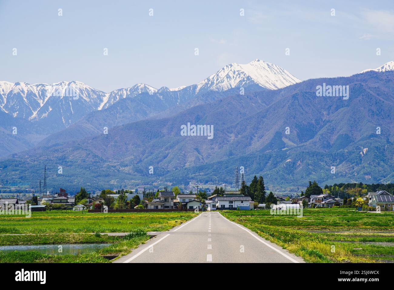 Route d'Ohisama et Mont Jonen | paysage printanier pittoresque avec une route droite et des Alpes japonaises enneigées à Azumino, Nagano, Japon Banque D'Images