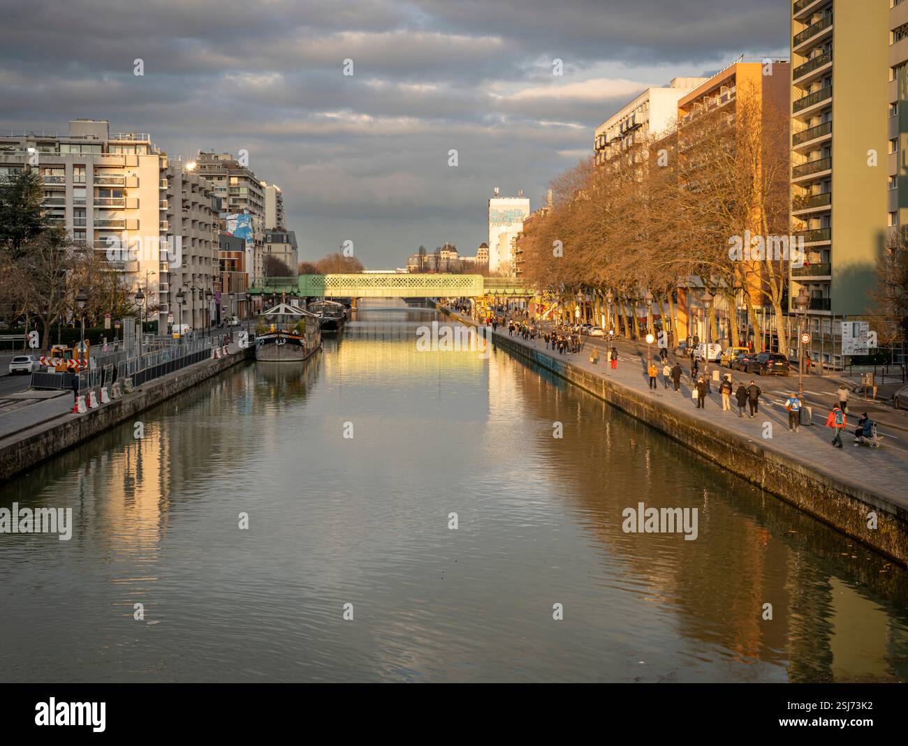 Paris, France - 02 01 2025 : vue sur le bassin de la Villette, les bateaux et le pont de la rue Ourcq depuis la passerelle au coucher du soleil Banque D'Images