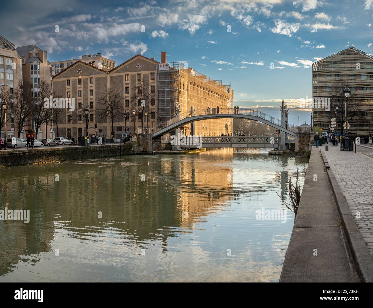 Paris, France - 02 01 2025 : vue sur le bassin de la Villette, le pont levant de Flandre et la passerelle au coucher du soleil Banque D'Images