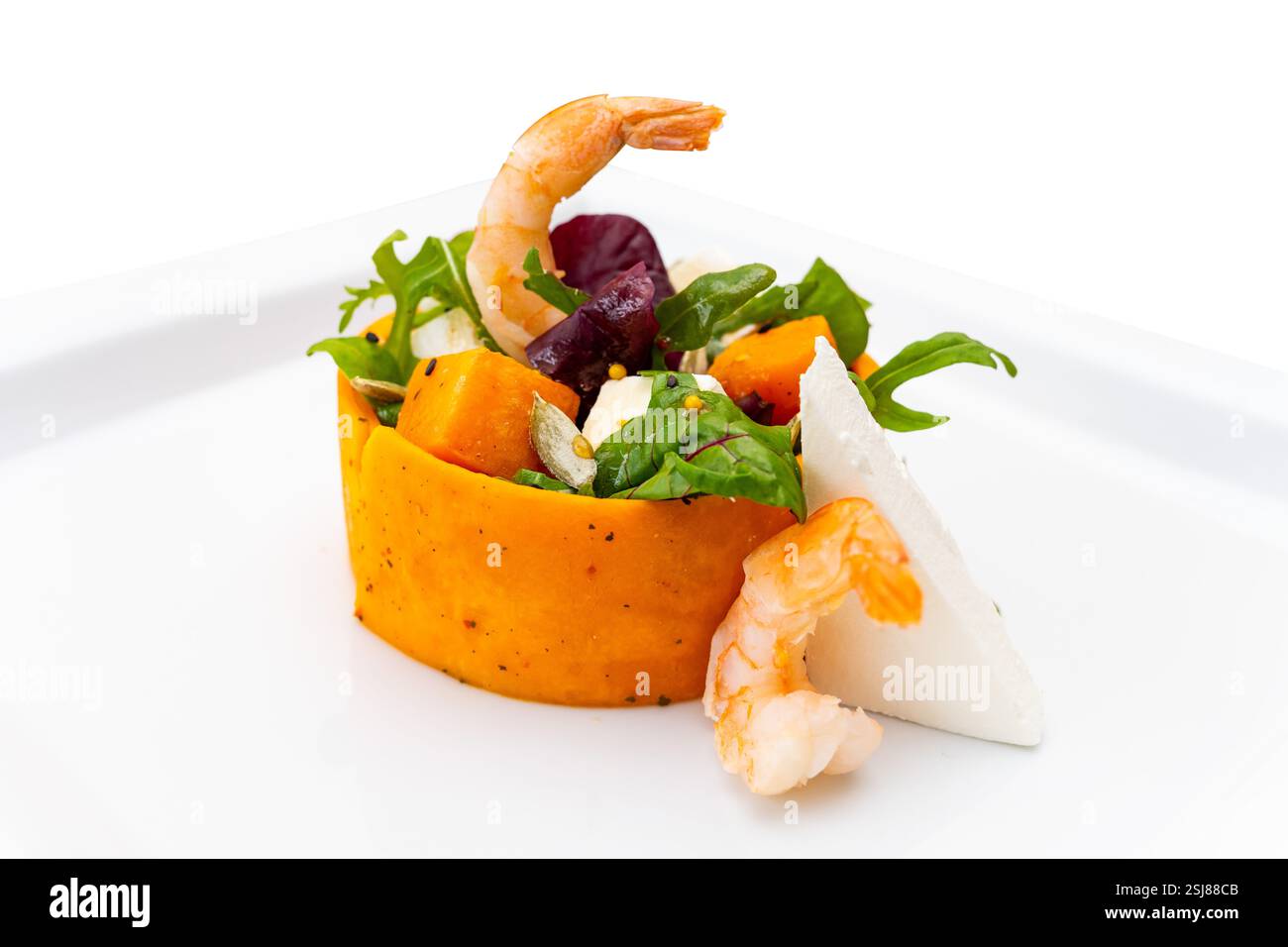La salade de crevettes vibrante se compose d'un mélange de légumes verts frais, de citrouille sucrée et de fromage, élégamment agencés pour une présentation attrayante. Parfait pour une lumière Banque D'Images
