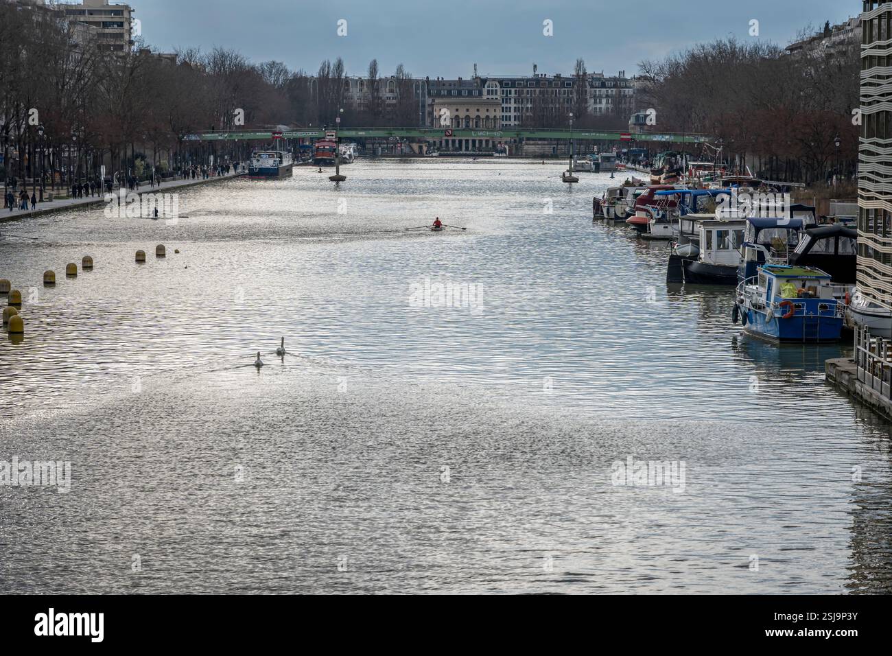 Paris, France - 02 08 2025 : vue sur le bassin de la Villette, les bateaux, la rotonde de Stalingrad et une paire de cygnes nageant dans l'eau pour la Saint-Valentin Banque D'Images
