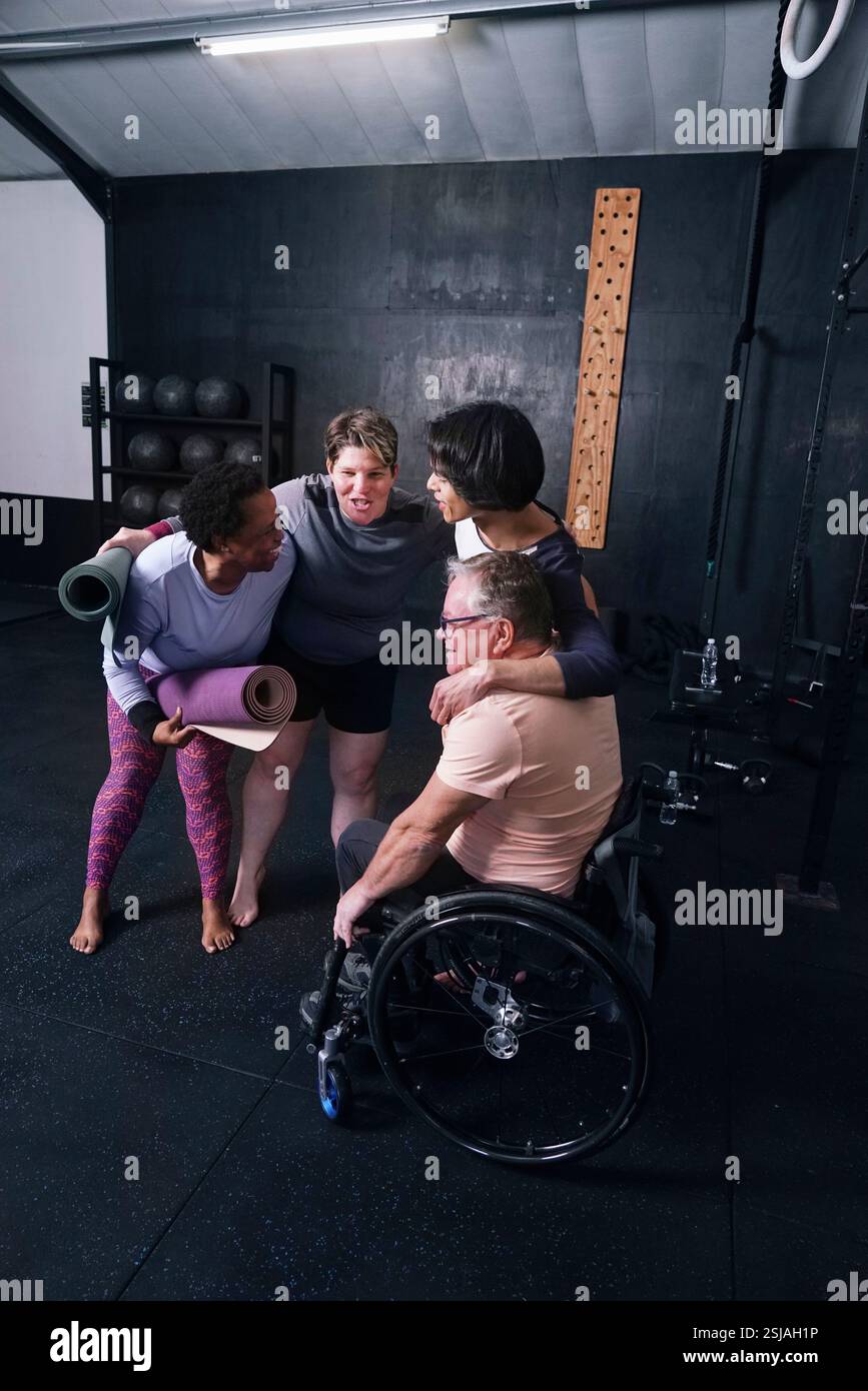 Amis souriants embrassant dans le studio de yoga Banque D'Images